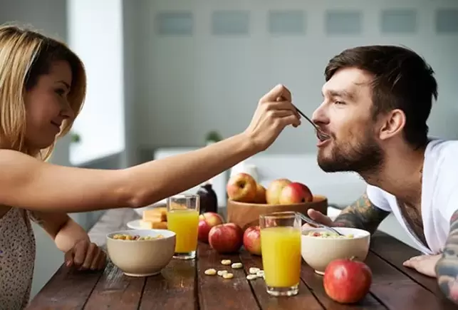 seorang wanita memberi makan lelaki dengan kacang untuk meningkatkan potensi